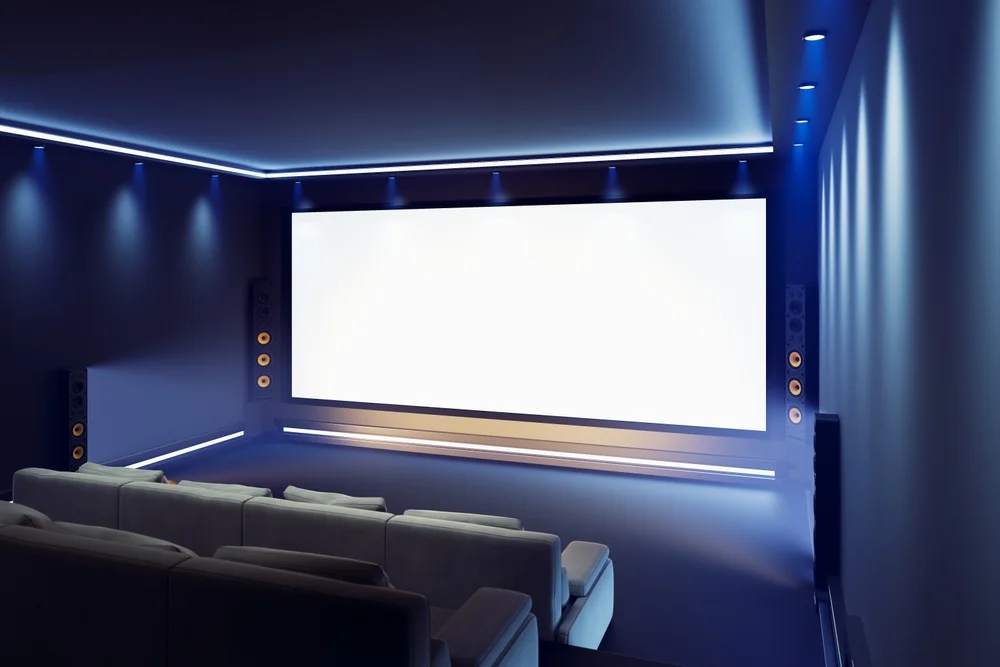 Modern home theater setup with large screen, ambient lighting, and comfortable seating, ideal for garage conversion ideas.